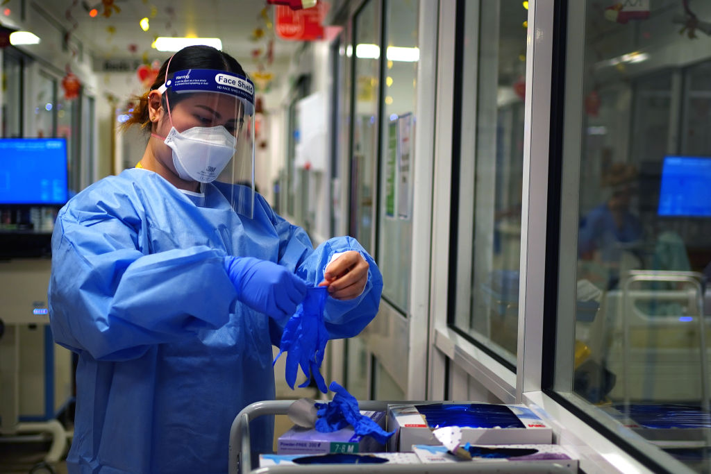 A nurse puts on PPE in a ward for Covid patients at King's College Hospital, in south east London.