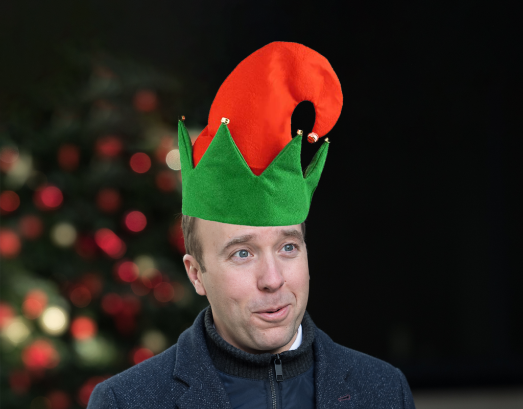 Matt Hancock, health secretary, stands in front of a door with a Christmas wreath. The image has been digitally altered so that it appears as though he is wearing a Christmas elf hat