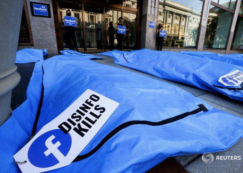 Several blue body bags with labels attached which read Disinfo Kills are lined up on the pavement outside Facebook's Washington DC offices