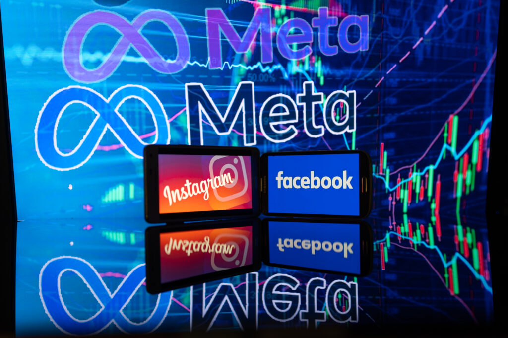 A photo illustration showing the Meta logo in the background with two smart phones in the foreground displaying the Instagram and FAcebook logos